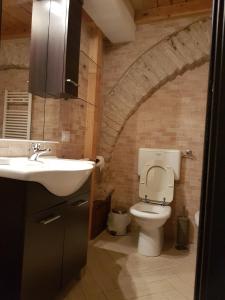 巴列塔Il Purgatorio的砖墙内带水槽和卫生间的浴室