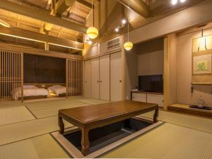 Totsukawa仙景汤乃谷日式旅馆的一间带木桌的客厅和一间卧室