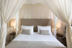 休达德亚S'Hotelet d'es Born - Suites & SPA的卧室配有白色床和白色窗帘