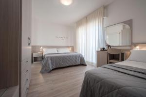 利多迪耶索罗安尼酒店 的酒店客房,设有两张床和镜子