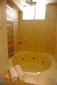 库斯科Hotel Waynapicchu的浴室配有带毛巾的大浴缸。