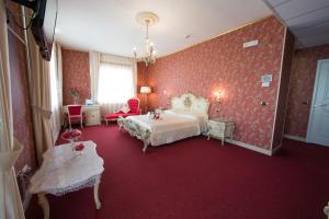Terzigno帝国酒店的卧室设有红色的墙壁、一张床和椅子