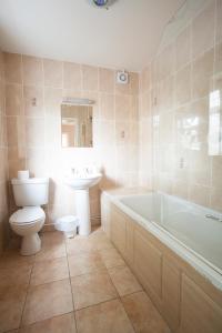 伍尔弗汉普顿男爵庭院酒店的浴室配有卫生间、浴缸和水槽。