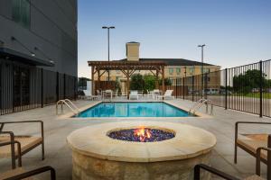 新布朗费尔斯Country Inn & Suites by Radisson, New Braunfels, TX的大楼前的一个带火坑的游泳池