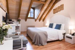 日内瓦卡鲁日社区酒店的一间带一张白色大床的卧室,位于带木制天花板的房间内