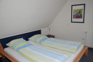 朗格奥Inselresidenz Seeschwalbe Langeoog的床上有两张带条纹枕头的床