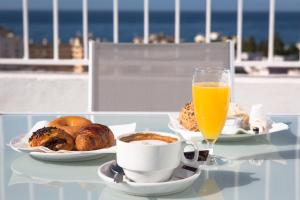 马贝拉Ona Marbella Inn的一张桌子,上面有早餐食品和一杯橙汁