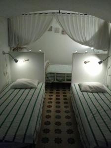 阿尔科斯-德拉弗龙特拉Casa Petra的带窗帘的客房内的两张单人床