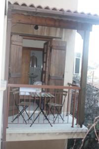 卡科佩特里亚Maritsa Lodge的阳台的门廊配有椅子和桌子
