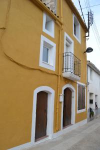 Sant Pere SacarreraCal Llorenç的黄色的建筑,设有两扇门和一个阳台