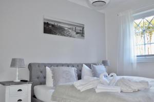 青斯特Villa Strandblick 10的白色卧室,配有带毛巾的床
