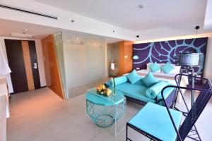 长滩岛HII长滩岛度假酒店的客厅配有蓝色的沙发和床。