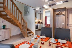 格洛韦Ferienhaus Ostseedüne Glowe - Rügen的一间带桌椅和楼梯的用餐室