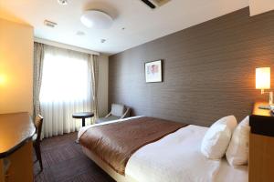 札幌札幌法华俱乐部酒店的一间设有大床和窗户的酒店客房