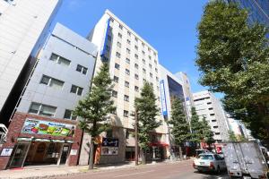 札幌札幌法华俱乐部酒店的城市街道上的一座建筑,有树木和汽车