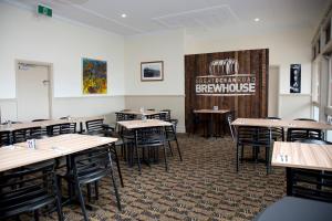 阿波罗湾Great Ocean Road Brewhouse Apollo Bay的一间设有桌椅和标志的用餐室