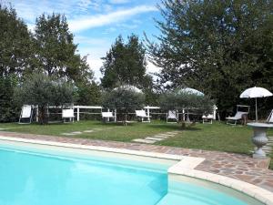 MontafiaVillagaia Country House的游泳池配有椅子、桌子和遮阳伞