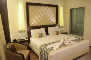 勒克瑙克拉克斯阿瓦德酒店的配有一张床和一把椅子的酒店客房