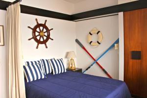塞辛布拉Akisol Sesimbra Beach的一间卧室配有一张蓝色的床和航海墙