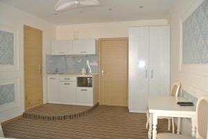 基辅Mini Hotel on Poznyaky的厨房配有白色橱柜、桌子和用餐室。
