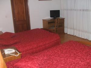 瓜尔达平托旅馆的酒店客房设有两张床和电视。