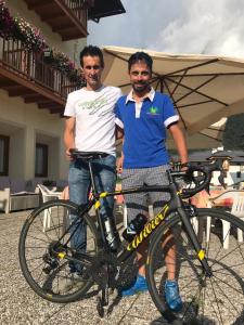 圣博沃塞雷内拉酒店的两个人站在自行车旁边