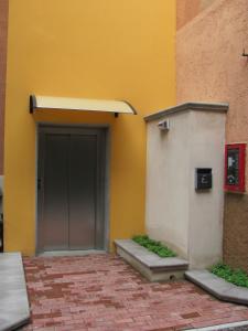 代西奥阿尔伯格加尔迪诺酒店的一座建筑,有灰色的门和黄色的墙壁