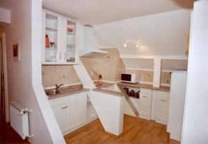 Neundorf李奇特度假旅馆的白色的厨房配有白色橱柜和水槽
