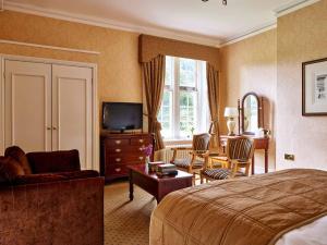 布罗德韦敦布尔顿厅酒店的酒店客房,配有床和电视