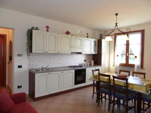 蒙泰卢波菲奥伦蒂诺Podere San Pierino的厨房配有白色橱柜和桌椅