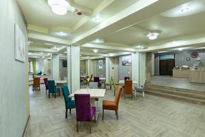 克拉约瓦Prestige Boutique Hotel Craiova的一间设有桌椅的房间和一间候客室