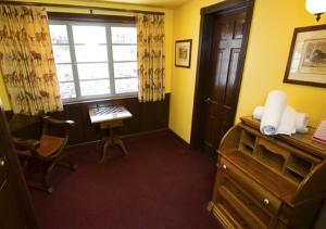 圣路易斯-奥比斯保玛丹娜酒店的客房设有书桌、窗户和椅子。