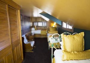 圣路易斯-奥比斯保玛丹娜酒店的一间火车房,配有两张床和一张沙发及椅子