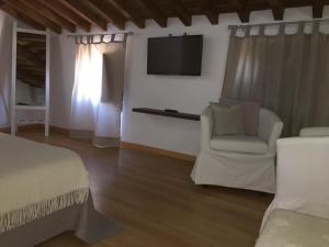 蒙萨拉什Refúgio da Vila的一间卧室配有一张床、一把椅子和电视