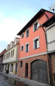 格但斯克旧城Willa BROWAR pokoje gościnne的一座橙色的建筑,在街上设有车库