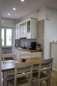 坎波巴索Casa Angela的厨房配有木桌和白色橱柜。