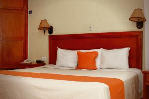比亚埃尔莫萨贝兹扎尔酒店的在酒店房间床上的橙色枕头