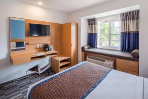 库利亚坎Microtel Inn & Suites by Wyndham Culiacán的配有一张床和一张书桌的酒店客房