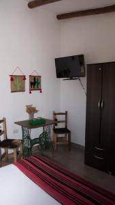 塔菲德尔瓦勒Cabañas Cultura Tafi的卧室配有1张床、1张桌子和1台平面电视