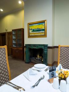 比勒陀利亚典雅门洛帕克旅舍的餐桌和壁炉,配有餐桌