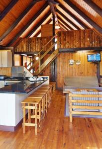 索德瓦纳湾First Group Sodwana Bay Lodge Self Catering的一间厨房,内设木制柜台和凳子
