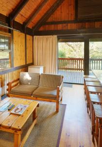 索德瓦纳湾First Group Sodwana Bay Lodge Self Catering的客厅配有沙发和桌子