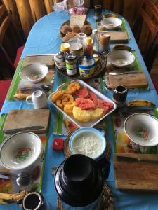 卡巴莱Amasiko Homestay Lake Bunyonyi的一张桌子,上面有蓝色桌布,上面有食物