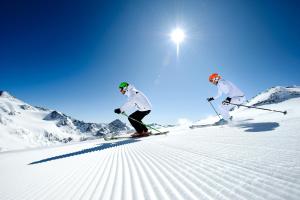施图拜河谷新施蒂夫特埃姆霍夫酒店的两个人在雪覆盖的斜坡上滑雪