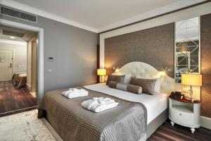 奥兹德雷Sunis Efes Royal Palace Resort & Spa的一间卧室配有一张大床和两条毛巾