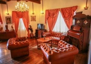 努沃勒埃利耶格伦德维尔酒店的客厅配有皮革家具和钢琴