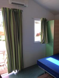 纳扎雷Parque de Campismo Orbitur Valado的一间设有绿色窗帘和窗户的客房