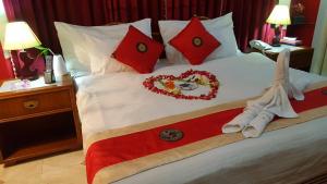 达卡巴比伦酒店及服务公寓的一张带红色枕头的床和装饰