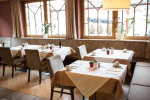索尔登Hotel Das Zentrum的餐厅设有白色的桌椅和窗户。