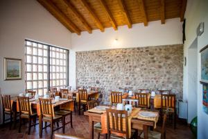 卡斯特努沃德加尔达加尔森林农家乐的一间设有木桌和椅子的餐厅以及石墙